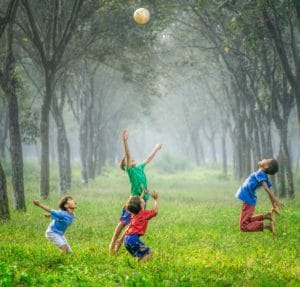Children playing ball in the woods
